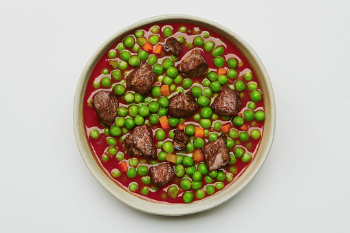Homemade peas with carrot and beef meat isolated on a white background, image with a copy space