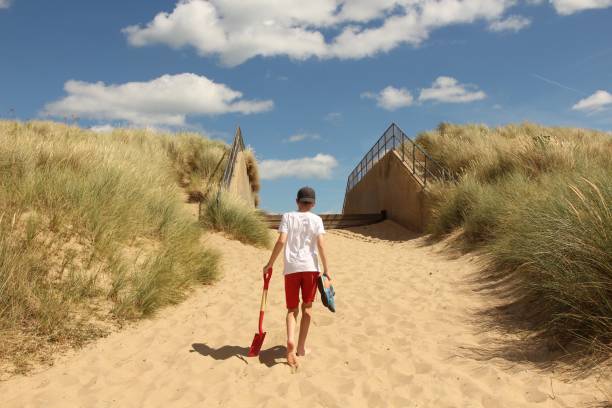 istock Young boy walking towards beach 1464270960