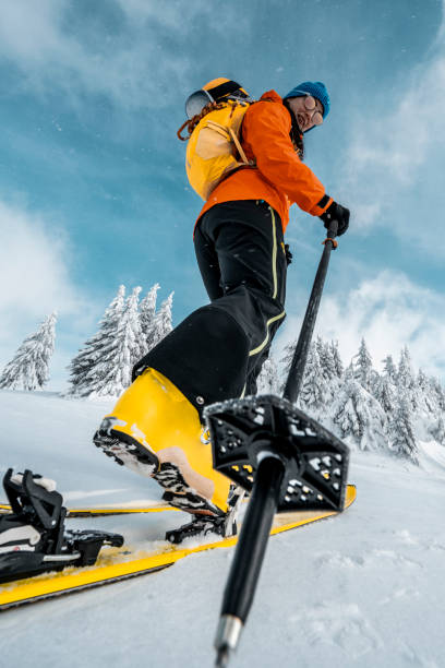 Close up on a boot, ski, binding and pole during ski touring adventure stock photo