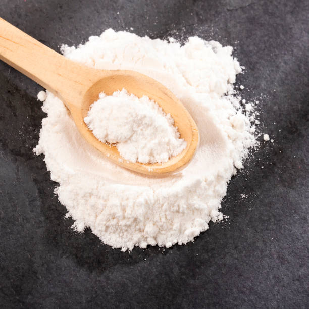 istock Sodium hydrogen carbonate - White baking soda in wooden spoon 1464272128