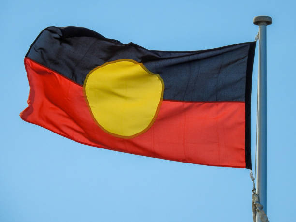 Bondi Pavillion Australian Aboriginal Flag The Australian Aboriginal flag flies in the wind on a flagpole next to the Bondi Pavillion at Bondi Beach, Sydney.  This image was taken on the windy and sunny afternoon of 2 February 2022. australian aborigine culture stock pictures, royalty-free photos & images