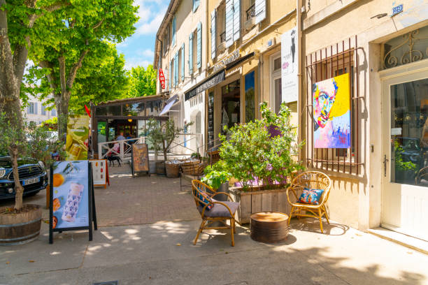 una encantadora y pintoresca calle de tiendas y cafés en la histórica ciudad medieval de saint-remy-de-provence en la región de provenza costa azul del sur de francia. - st remy de provence fotografías e imágenes de stock