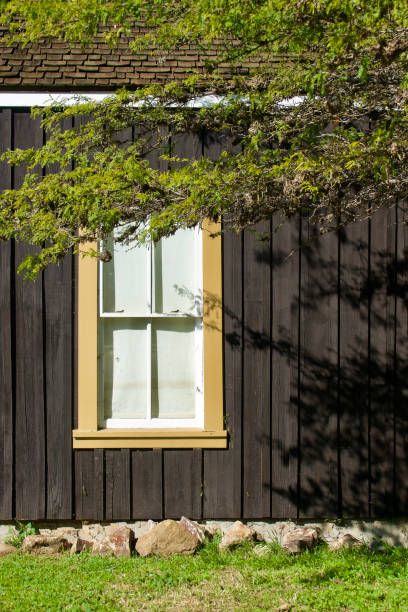 gelb gerahmtes fenster auf einem dunkelbraun gebeizten holzgebäude - house san diego california old town architecture stock-fotos und bilder