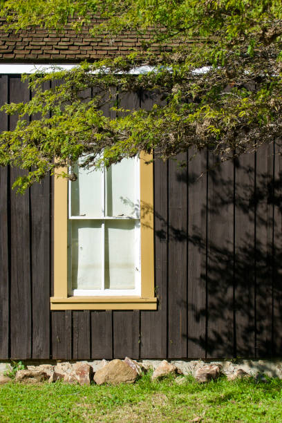 желтое окно в рамке на темно-коричневом окрашенном деревянном здании - house san diego california old town architecture стоковые фото и изображения