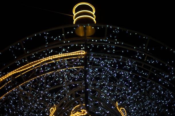 Garlands are arranged in arc. Urban decoration. Bright light bulbs. Garland construction.