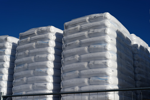 Cologne, Germany, February 08 2023 : shrink-wrapped grain sacks on pallets awaiting loading at the port of cologne niehl