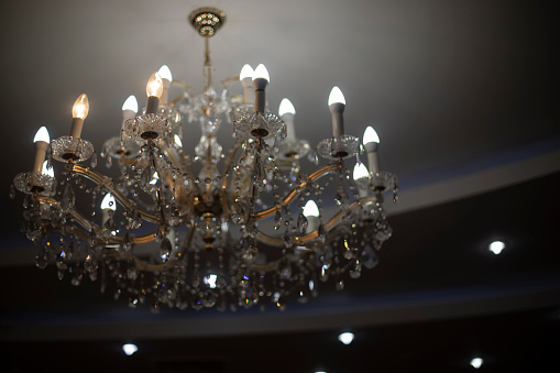 Chandelier on ceiling. Crystal chandelier in chamber. Expensive interior. Light design.