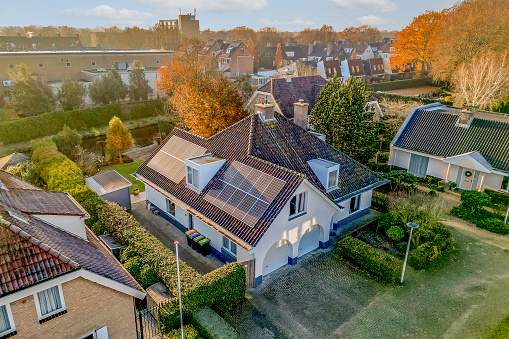 some houses with solar panels on the roof and one house in the fore - image is an aerial view from above