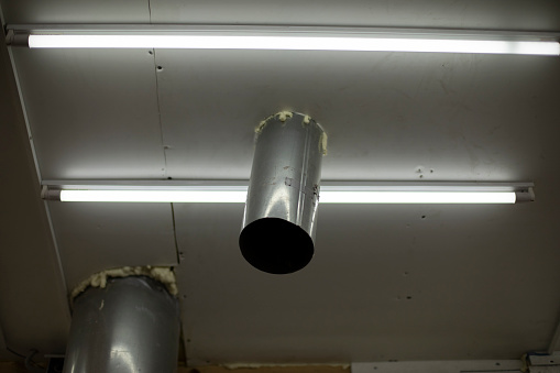 Pipe in ceiling. Pipe comes out of roof inside. Steel profile. Ceiling with hole.