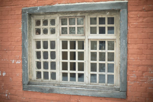 Window with grille in wall. Old window. Wall of house. Wooden lattice.
