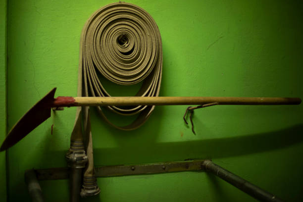 Green garden hose isolated on white partly defocused