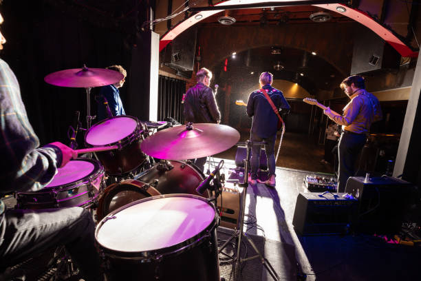 istock Rear View of Band Doing Soundcheck On Stage from Behind Drum Kit 1464300592