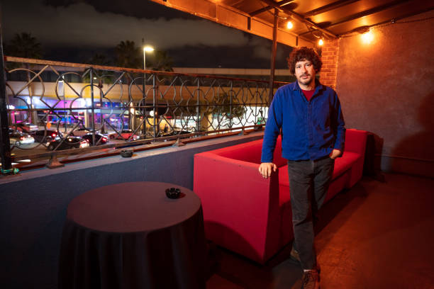 istock Man Standing Next to Couch in Nightclub Smoking Area 1464300644