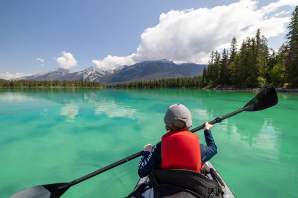istock Cute Little Boy Paddleboarding on Edith Lake, Jasper National Park, Alberta, Canada 1464313549