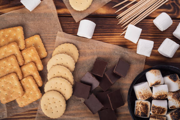 istock marshmallows, chocolate and cookies for making smore on brown background. view from above. copy space 1464314350