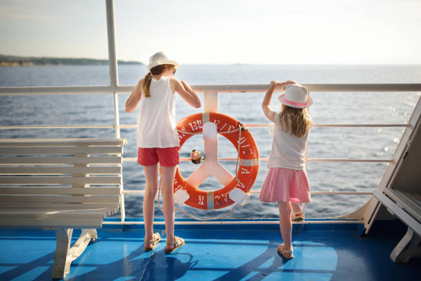Adorable young girls enjoying ferry ride staring at the sea on sunset. Children having fun on summer family vacation in Greece. Adorable young girls enjoying ferry ride staring at the sea on sunset. Children having fun on summer family vacation in Greece. Kid sailing on a boat. ferry deck girls stock pictures, royalty-free photos & images