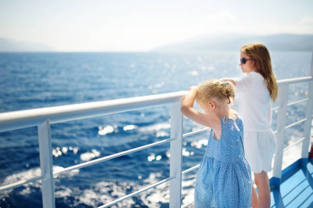 Adorable young girls enjoying ferry ride staring at the deep blue sea. Children having fun on summer family vacation in Greece. Adorable young girls enjoying ferry ride staring at the deep blue sea. Children having fun on summer family vacation in Greece. Kid sailing on a boat. ferry deck girls stock pictures, royalty-free photos & images