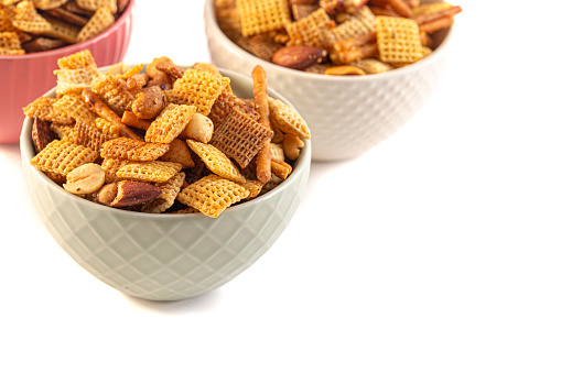 Serving of Homemade Cereal Nut and Prezel Trail Mix Isolated on a White Background