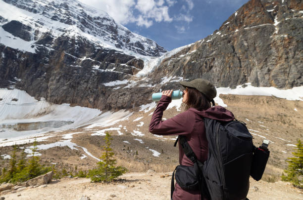 istock Young Woman Drinking Water at Mount Edith Cavell, Jasper, Canada 1464317400
