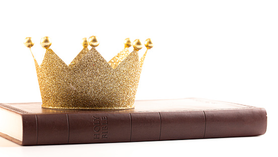 Corona de oro en una Santa Biblia aislada sobre un fondo blanco photo