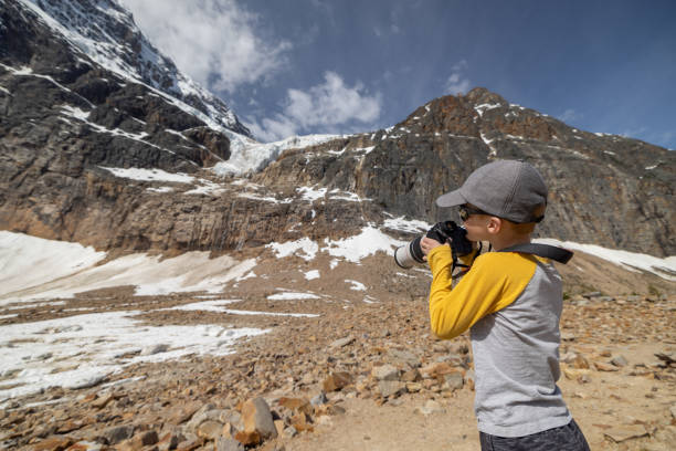 istock Young Redhead Boy Taking Picture with a Digital Camera at Mount Edith Cavell, Alberta, Canada 1464317661