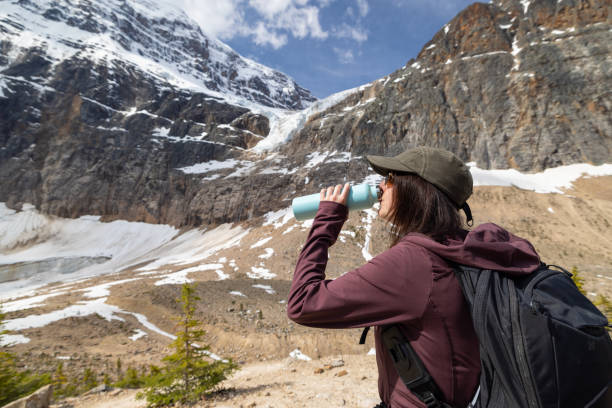 istock Young Woman Drinking Water at Mount Edith Cavell, Jasper, Canada 1464317693