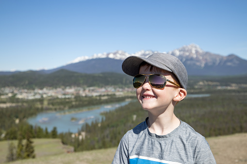 Happy Young Hiker Boy at the Old Fort Point Hiking Trail, Jasper, Alberta, Canada on a nice day of summer. The Canadian Rockies are in the background.