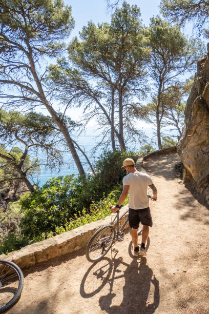 istock Young man cycling by the coastline in Spain 1464319033
