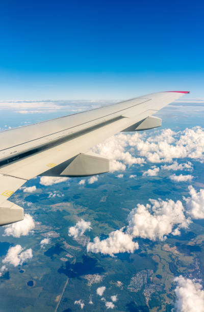 istock View from the airplane window at a beautiful cloudy sky and the airplane wing 1464320863