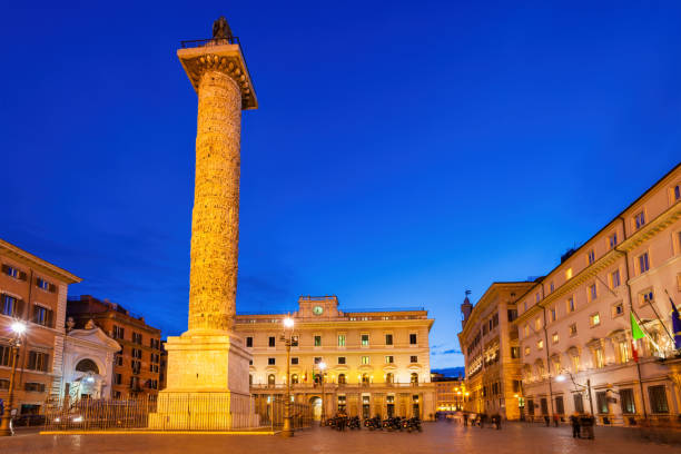 Column of Marcus Aurelius and the Palazzo Chigi on the right (official residence of the Italian Prime Minister) on Piazza Colonna in downtown Rome Italy at night.