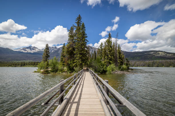 Wooden bridge in Pyramid lake with colorful sky at evening. Jasper national park, Canada