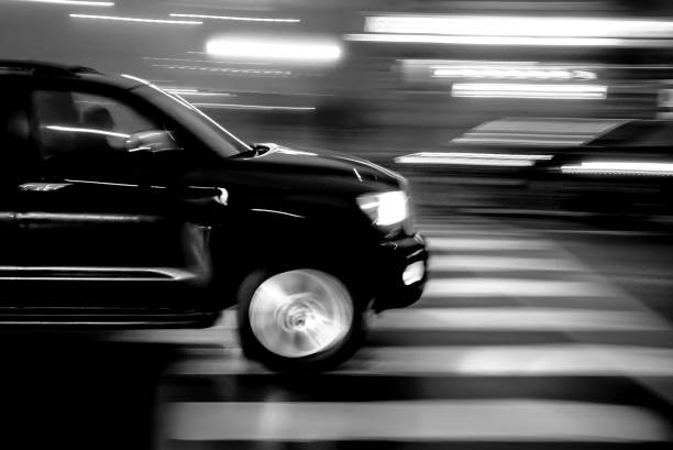 BLACK CAR AT NIGHT IN MOTION BLUR stock photo