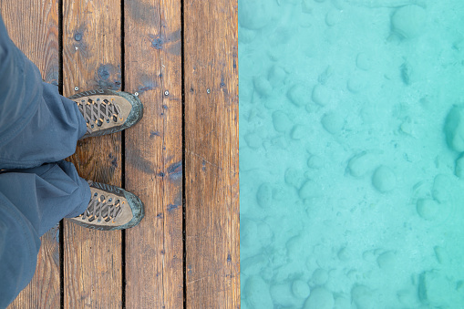 Man Feet and Hiking Boots at Lake Annette Deck and Water Background, Jasper, Alberta, Canada