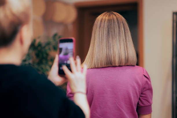 Hairdresser Taking a Picture of her Client with a New Look Professional hairstylist photographing the result for her online portfolio medium length hair stock pictures, royalty-free photos & images