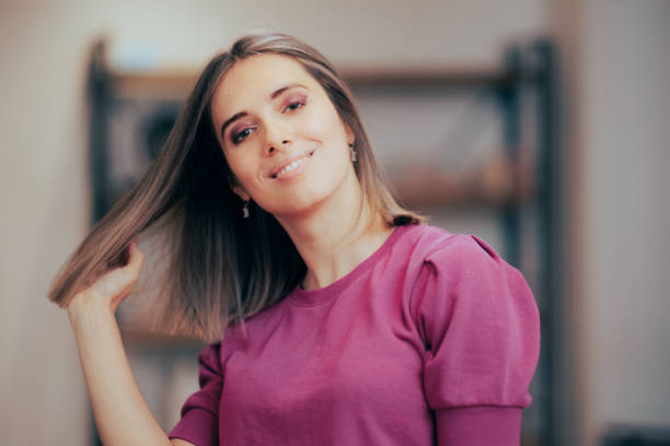 Beautiful Woman Showing Off Her New Haircut and Hair Color Pretty lady presenting her hair in motion enjoying new look medium length hair stock pictures, royalty-free photos & images