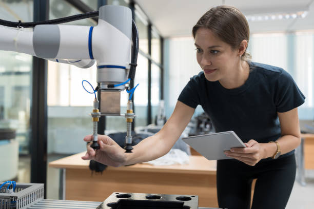 istock Female engineer training or maintenance AI robot in the manufacturing automation and robotics laboratory room 1464335297
