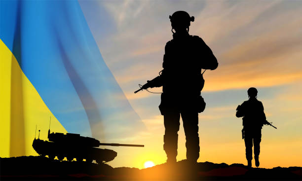 Silhouettes of a soldiers and a main battle tank Silhouettes of a soldiers and a main battle tank on a battlefield with Ukraine flag against the sunset. EPS10 vector ukraine war stock illustrations