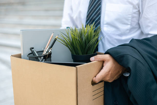 Businessman with box cardboard packing personal items after losing jobs. Failure businessman standing at front of building. Your fired Unemployed Jobless People Crisis Businessman with box cardboard packing personal items after losing jobs. Failure businessman standing at front of building. Your fired Unemployed Jobless People Crisis firing stock pictures, royalty-free photos & images