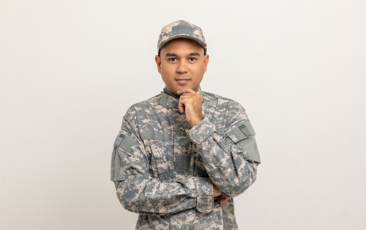 Thinking Asian man special forces soldier standing in studio. Commander Army soldier military defender of the nation in uniform standing on white background.