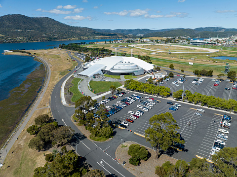 MyState Bank Arena from the air in Glenorchy, Tasmania on a clear summer day, with patrons attending Tasmanian Jack Jumpers NBL basketball game