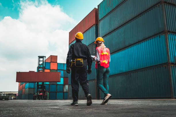 industrial worker works with co-worker at overseas shipping container yard . logistics supply chain management and international goods export concept . - nautical vessel business cargo container shipping imagens e fotografias de stock