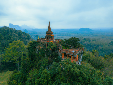 Scenic aerial view of buddhist temple on the mountain top surrounded by the jungles in Thailand
