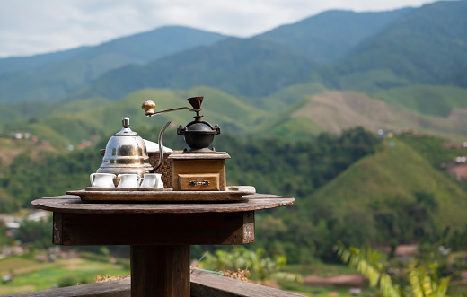 Close-up of fresh tea and coffee set with the mountain view in the morning for the background. Nan province, The north of Thailand.