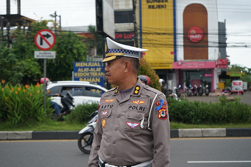 Makassar, Indonesia - February 9 2023: Portrait of Indonesian police officers patrolling the main road