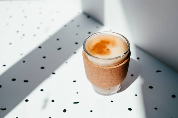 istock Coffee cup close up in contrast sunlight on white background with black dots. 1464354315