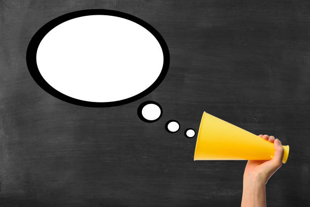 istock Hand holding megaphone with blank speech bubble on blackboard 1464357466