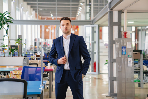 a man in ablue business suit in the coworking office. the concept of the portrait of an entrepreneur. career. simple and comfortable clothes for an office worker. office for rent