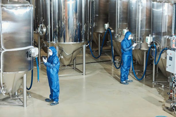 istock Wide angle view at factory workshop with two workers operating storage tanks 1464359336