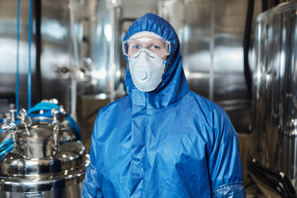istock Worker wearing protective gear and looking at camera at chemical plant 1464360107