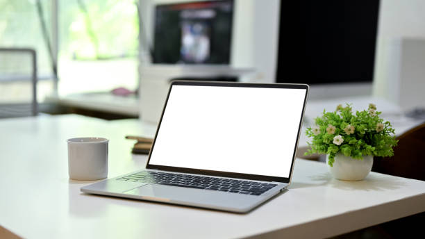 istock Laptop white screen mockup is on a modern office desk. close-up image 1464361947